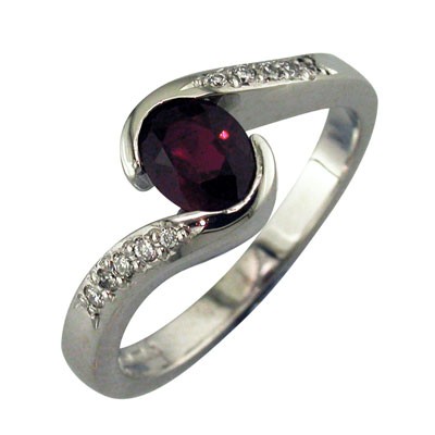 Oval ruby twist style platinum ring with pave set diamond shoulders