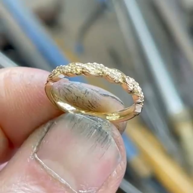 18 ct diamond twist band with hand carving on one size and diamonds on the other