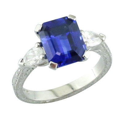 Platinum three stone ring with emerald cut sapphire and pear cut diamonds