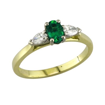 Platinum and yellow gold three stone ring with an oval emerald and pear-shaped diamonds