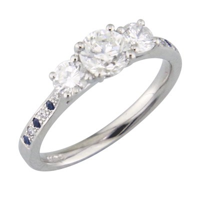 Three stone diamond ring with sapphire and diamond grain set shoulders