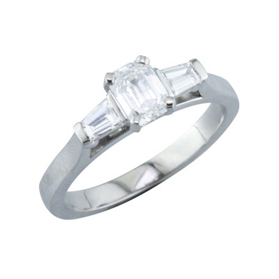 Emerald cut diamond three stone platinum ring with tapered baguette cut diamonds