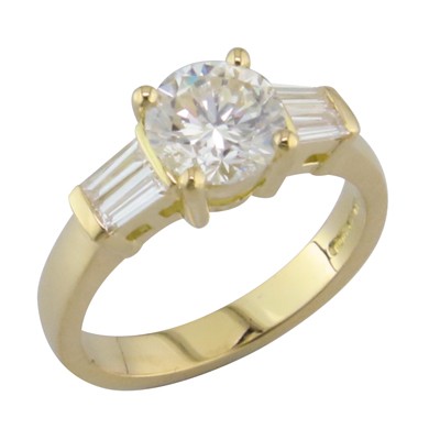 18ct yellow gold ring with a round cut diamond in the middle and two baguette cut diamond in each shoulder