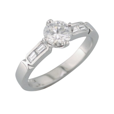 Platinum and diamond single stone ring with baguette cut diamond set in the shoulders
