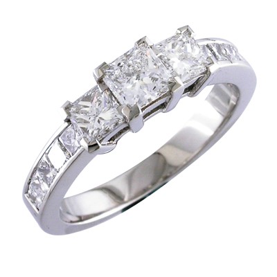 Princess cut three stone ring with channel set shoulders.