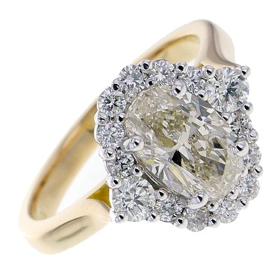 Yellow oval shaped diamond halo cluster ring with a platinum setting and yellow gold shank