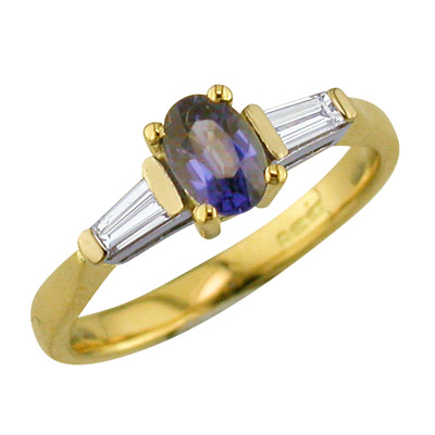 Sapphire and tapered baguette cut diamond three stone ring in yellow gold