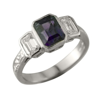Colour change purple sapphire three stone ring with emerald cut diamonds and hand engraved shoulders